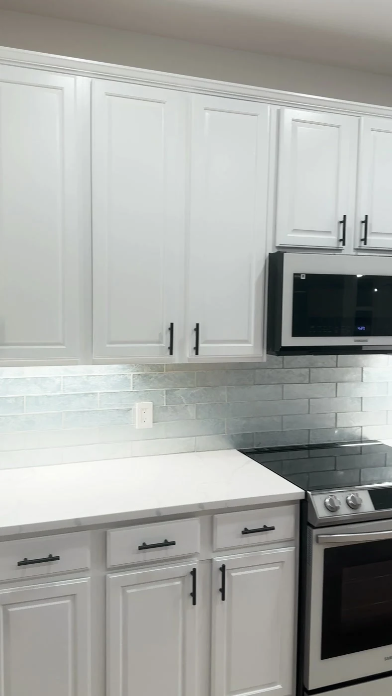 Detalhe da zona de bancadas em quartzo, armários brancos e iluminação LED sob armários, cozinha Maple Grove Minnesota