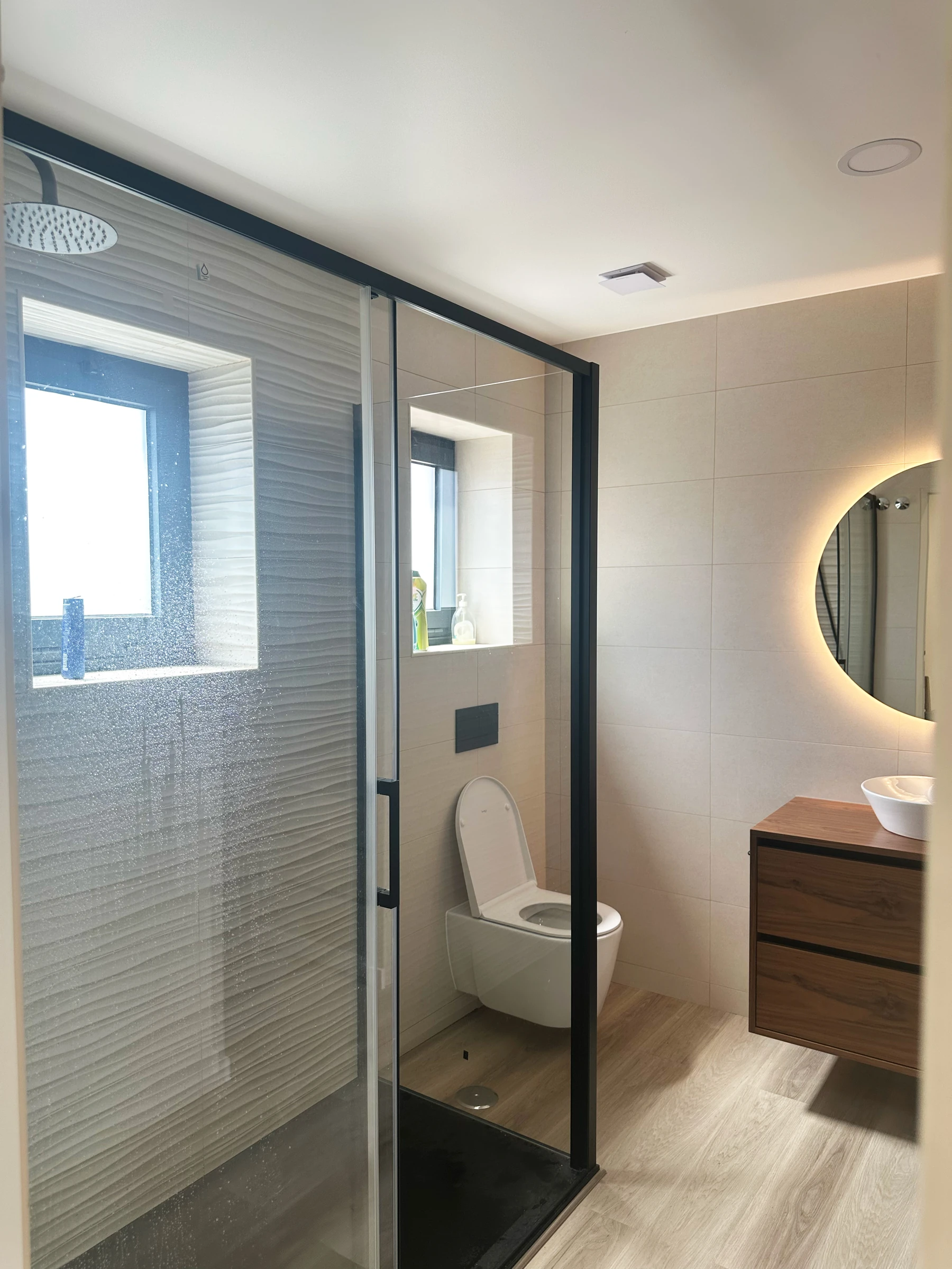 Vista do lavatório de pousar em móvel suspenso de madeira natural com ferragens em preto mate, suite em Estarreja, Aveiro