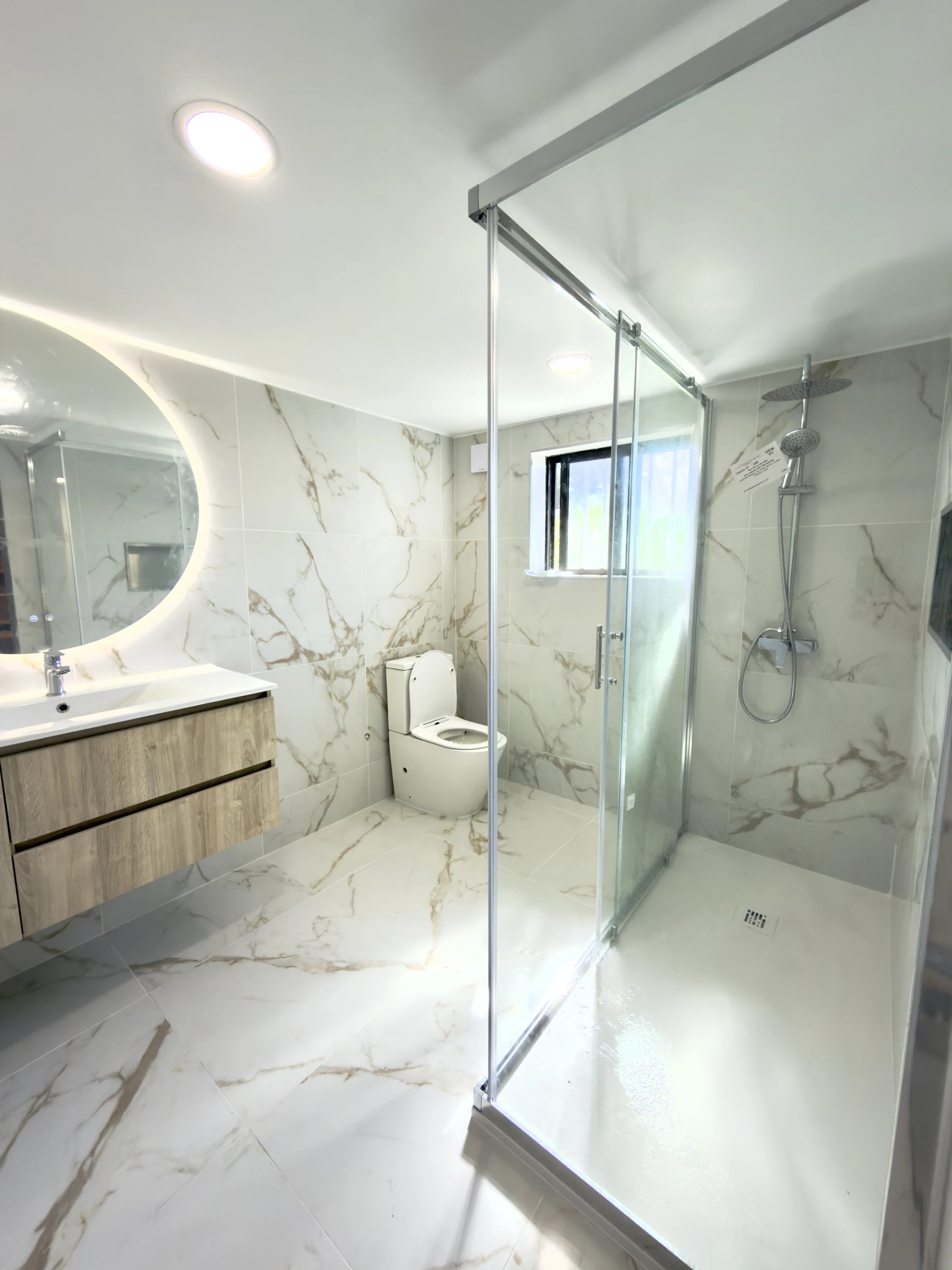 Casa de banho moderna em Estarreja, Aveiro, com revestimento cerâmico efeito mármore, duche walk-in e móvel suspenso em madeira natural — remodelação VPObras